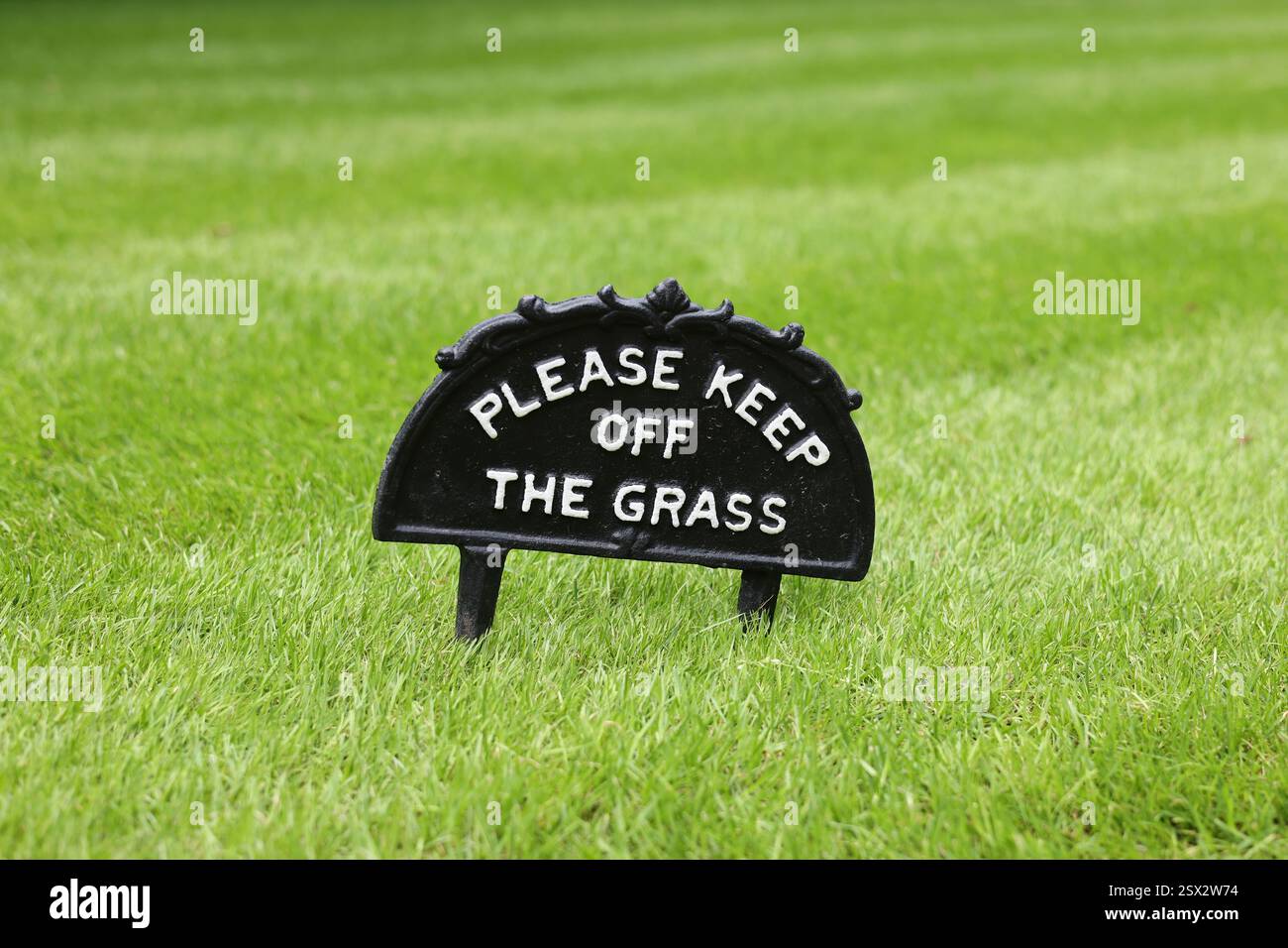 S'il te plaît, reste à l'écart de l'herbe. Signe en fonte vintage sur une pelouse bien entretenue dans un parc britannique Banque D'Images