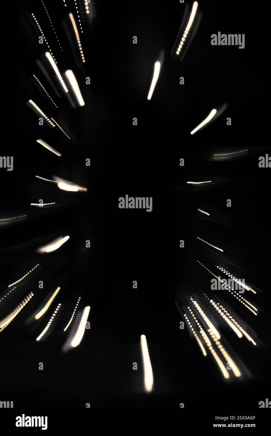 Traînées de lumière sortant du centre de l'arrière-plan noir Banque D'Images