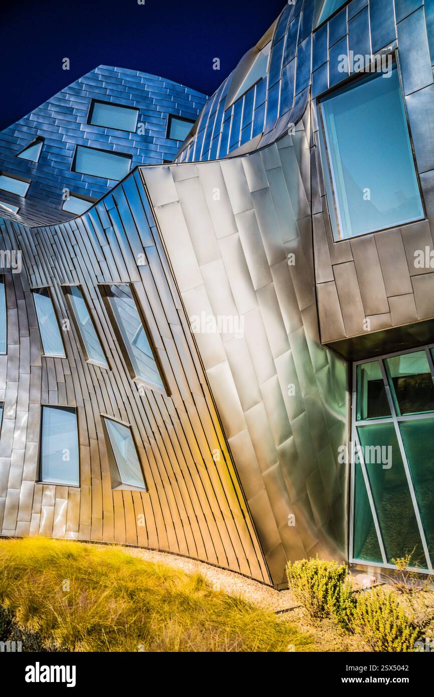 Bâtiment avec beaucoup de fenêtres et un toit en métal. Le toit est argenté et le bâtiment est haut Banque D'Images