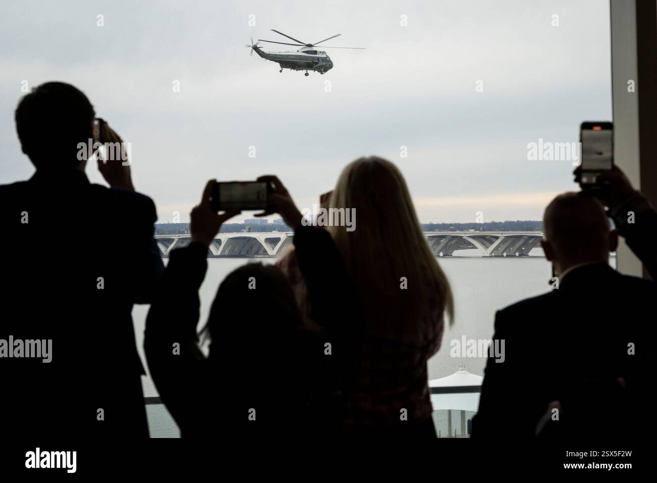 Oxon Hill, États-Unis. 22 février 2025. Les participants se rassemblent devant une fenêtre alors que le président américain Donald Trump décolle de Marine One pour retourner à la Maison Blanche après avoir pris la parole, au cours du troisième jour de la Conférence d’action politique conservatrice 2025, au Gaylord National Resort & Convention Center, à Oxon Hill, Maryland, le samedi 22 février, 2025. (Graeme Sloan/Sipa USA) crédit : Sipa USA/Alamy Live News Banque D'Images