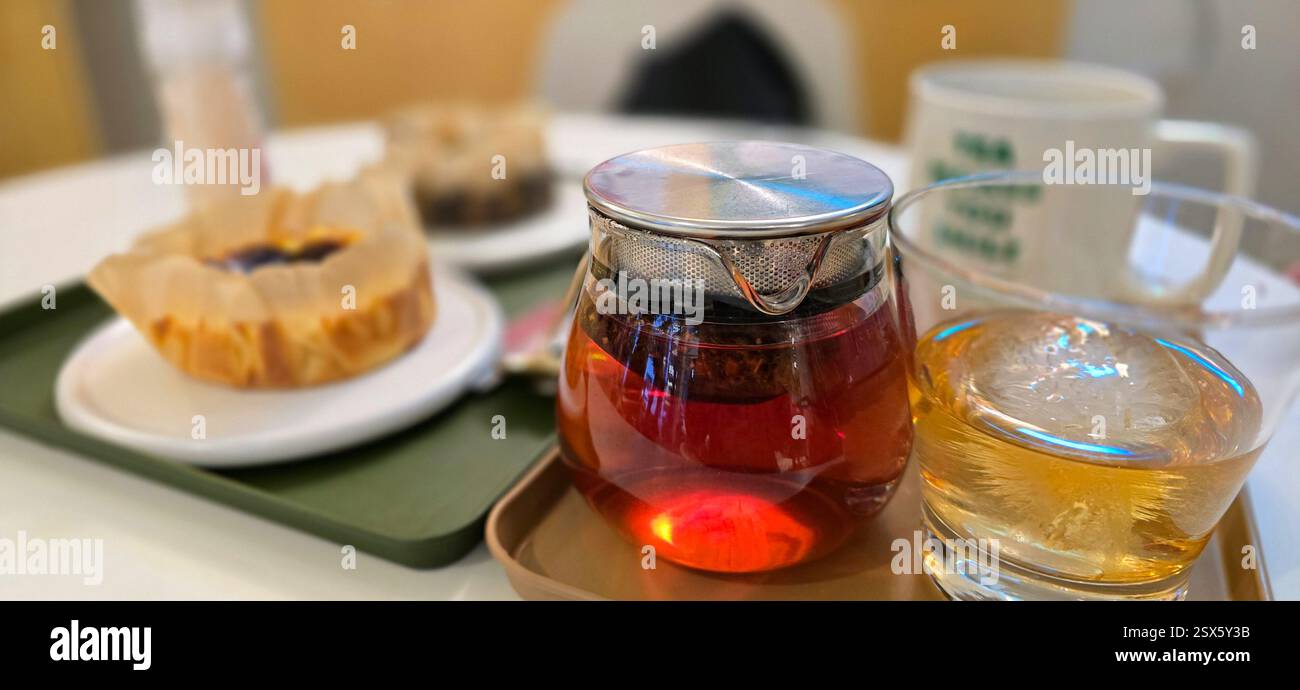 Thé noir, boule de glace, tasse de café, gâteau sur la table au café Banque D'Images