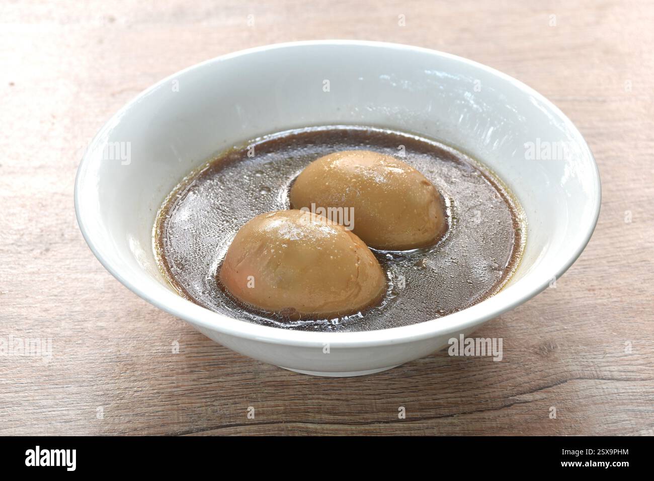 Ragoût d'oeuf à la coque dans une soupe chinoise d'os de porc brun aux herbes sur un bol Banque D'Images