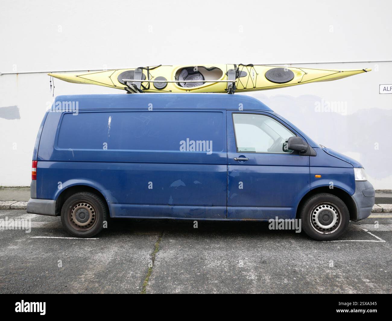 Camionnette bleue avec kayak jaune sur son toit. Banque D'Images Camionnette bleue avec kayak jaune sur son toit. Banque D'Images