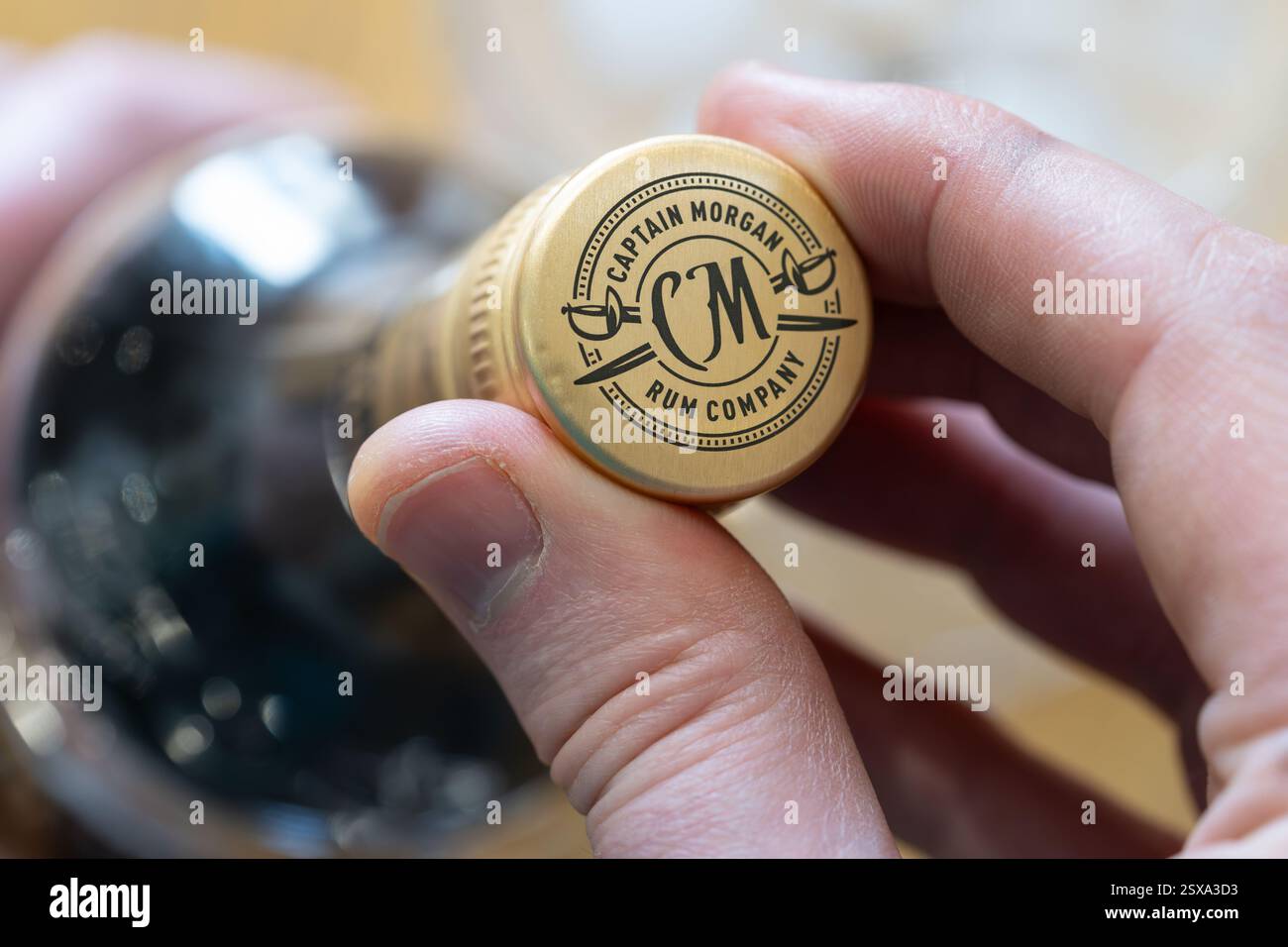 Main d'homme dévissant un bouchon à vis sur une bouteille d'une bouteille de spiritueux de qualité supérieure de rhum foncé de la Captain Morgan Rum Company, propriété de Diageo. ROYAUME-UNI Banque D'Images