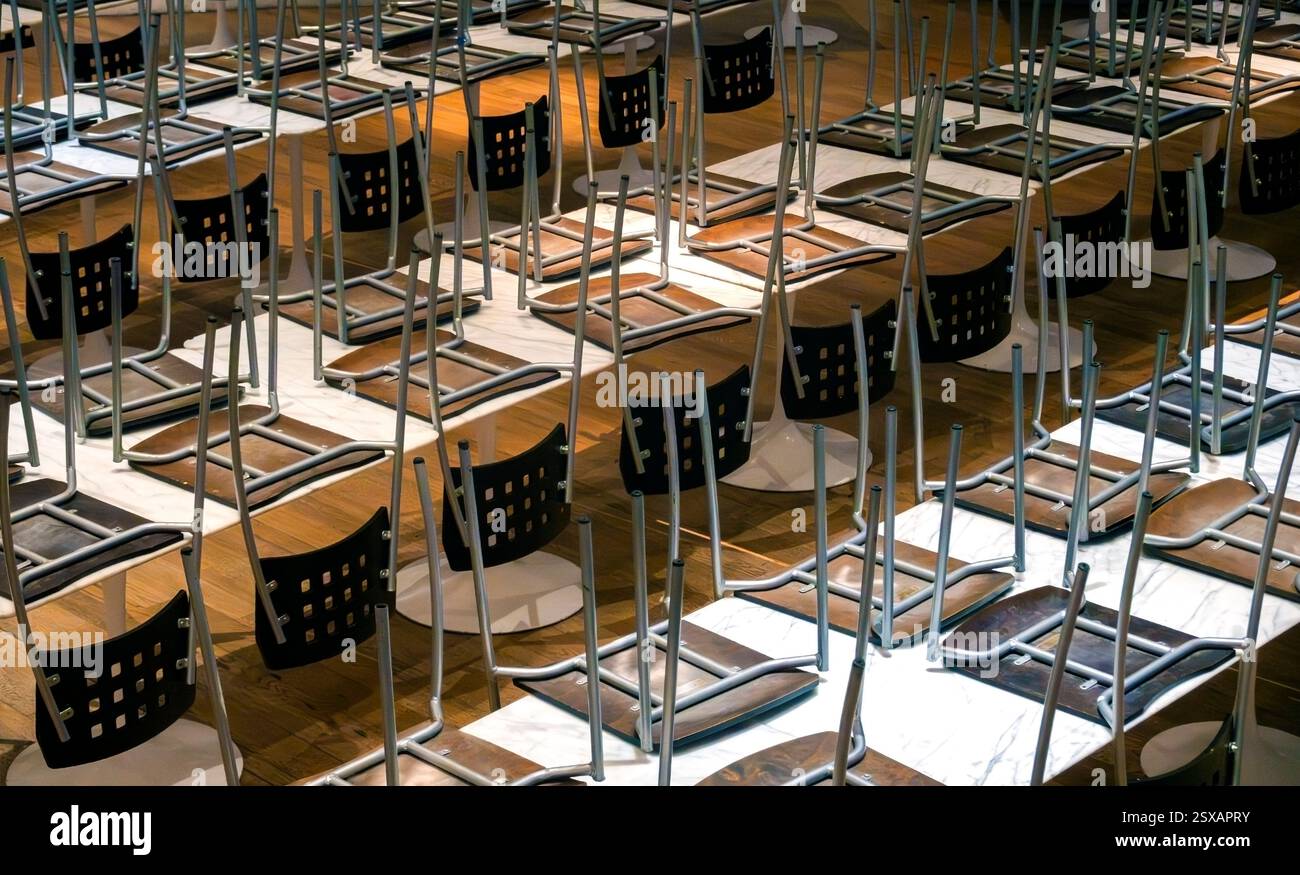 Chaises de cantine posées sur le dessus des tables Banque D'Images
