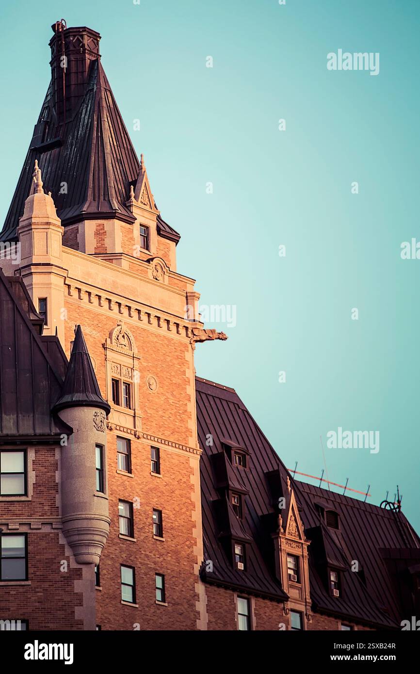 Grand bâtiment avec un clocher et une horloge sur le devant. Le bâtiment est brun et a un toit noir Banque D'Images