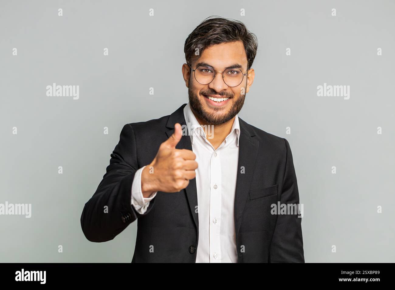 J'aime. L'homme d'affaires indien soulève les pouces vers le haut est d'accord avec quelque chose ou donne une réponse positive recommande la publicité aime la rétroaction de bonne idée, célébrant la victoire de succès. Homme isolé sur fond gris Banque D'Images