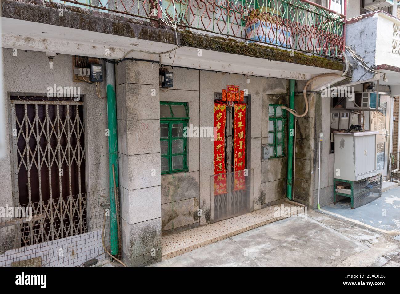 Hong Kong. Chine- 02.13.2025. Des couplets de printemps chinois accrochés à la porte d'une maison de village de style ancien. Banque D'Images