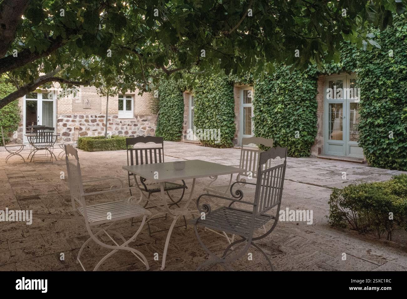Patio avec chaises, table, arbres et plantes sur la terrasse du bar du Parador de Turismo dans la ville d'Almagro, province de Ciudad Real, Espagne Banque D'Images
