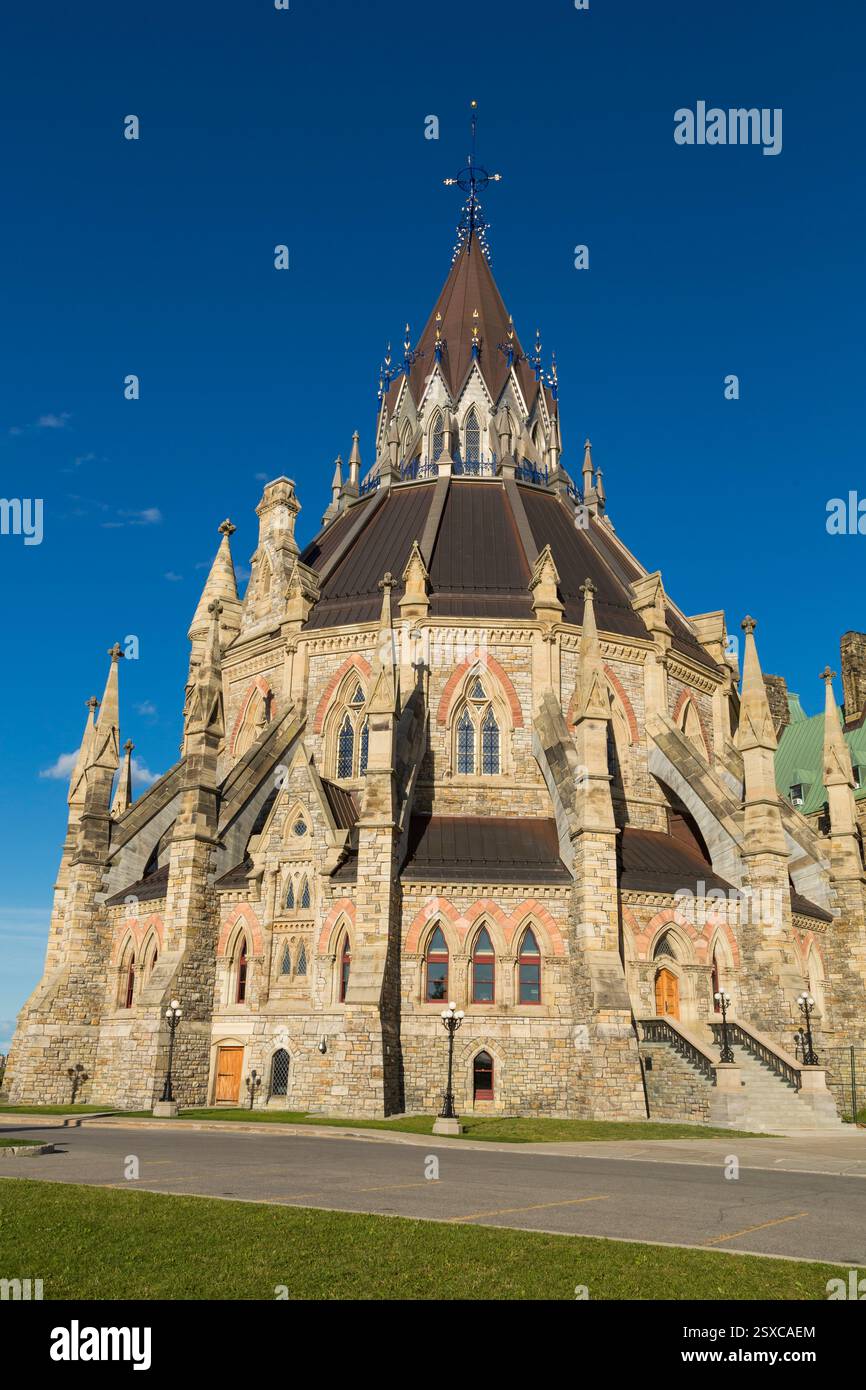 Grand bâtiment avec un clocher et une tour de l'horloge. Le bâtiment est en pierre et a un toit rouge Banque D'Images