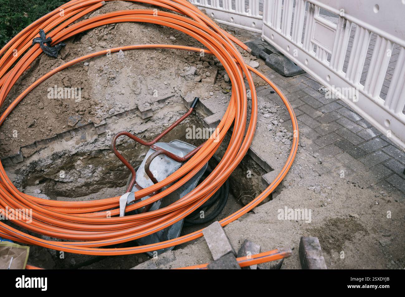 Fosse avec câbles orange et outils de construction Banque D'Images