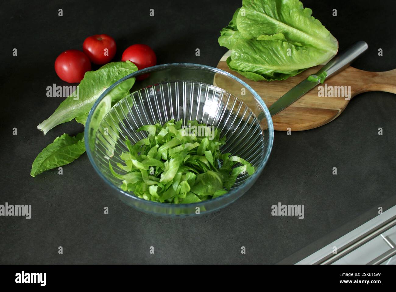 Vue de dessus de laitue romaine verte fraîche sur planche à découper en bois et dans un bol Banque D'Images