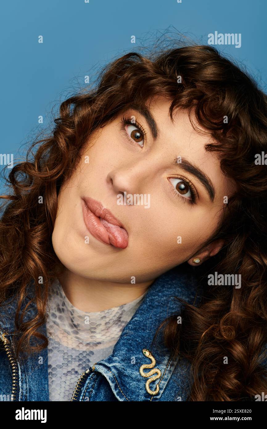 La jeune femme met en valeur son style tendance et son expression émotionnelle avec un geste ludique. Banque D'Images