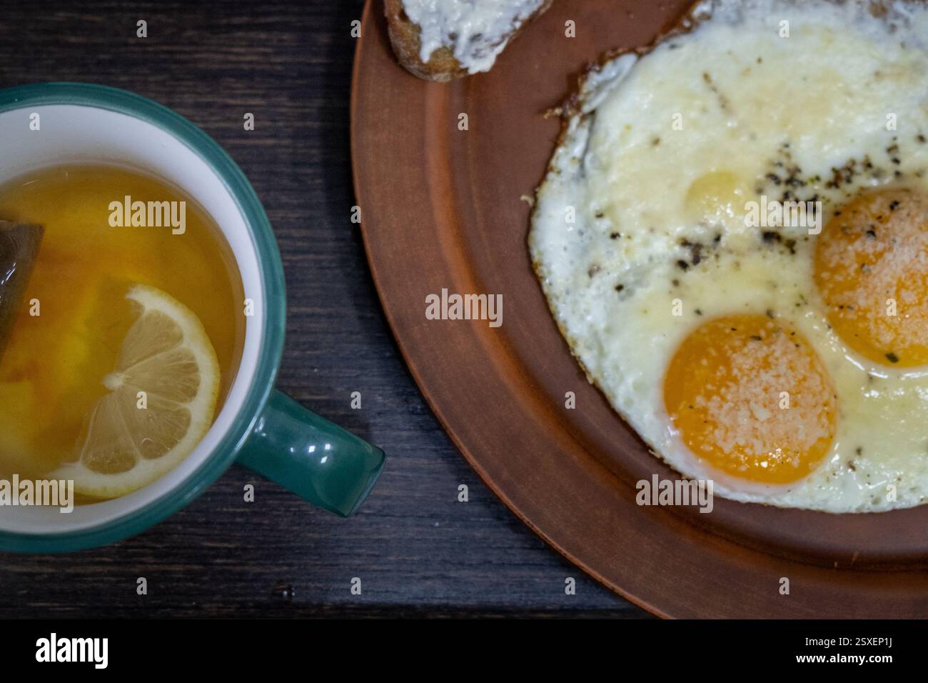 Petit-déjeuner avec œufs ensoleillés et thé au citron Banque D'Images