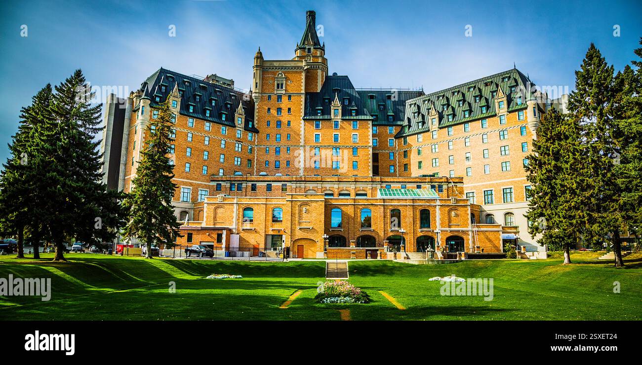 Grand bâtiment en briques avec un toit vert. Le bâtiment dispose d'une grande cour avec une zone herbeuse Banque D'Images