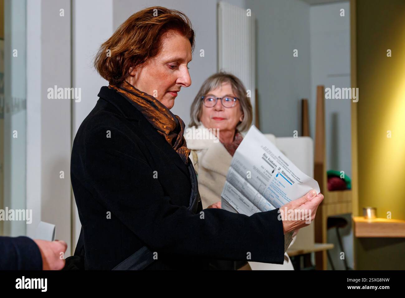 Britta Ernst, épouse du chancelier Olaf Scholz, attend dans le bureau de vote de l'IHK Potsdam - un autre visiteur en arrière-plan - les élections pour le Banque D'Images