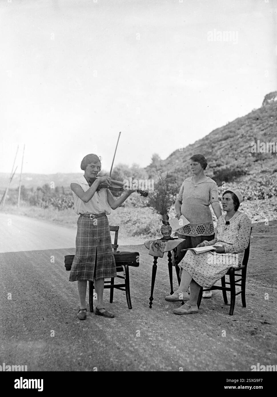 Violoniste amateur français joue un concert en plein air ou a une leçon de musique en plein air France. Vintage ou historique noir et blanc ou monochrome image c1930 Banque D'Images Violoniste amateur français joue un concert en plein air ou a une leçon de musique en plein air France. Vintage ou historique noir et blanc ou monochrome image c1930 Banque D'Images