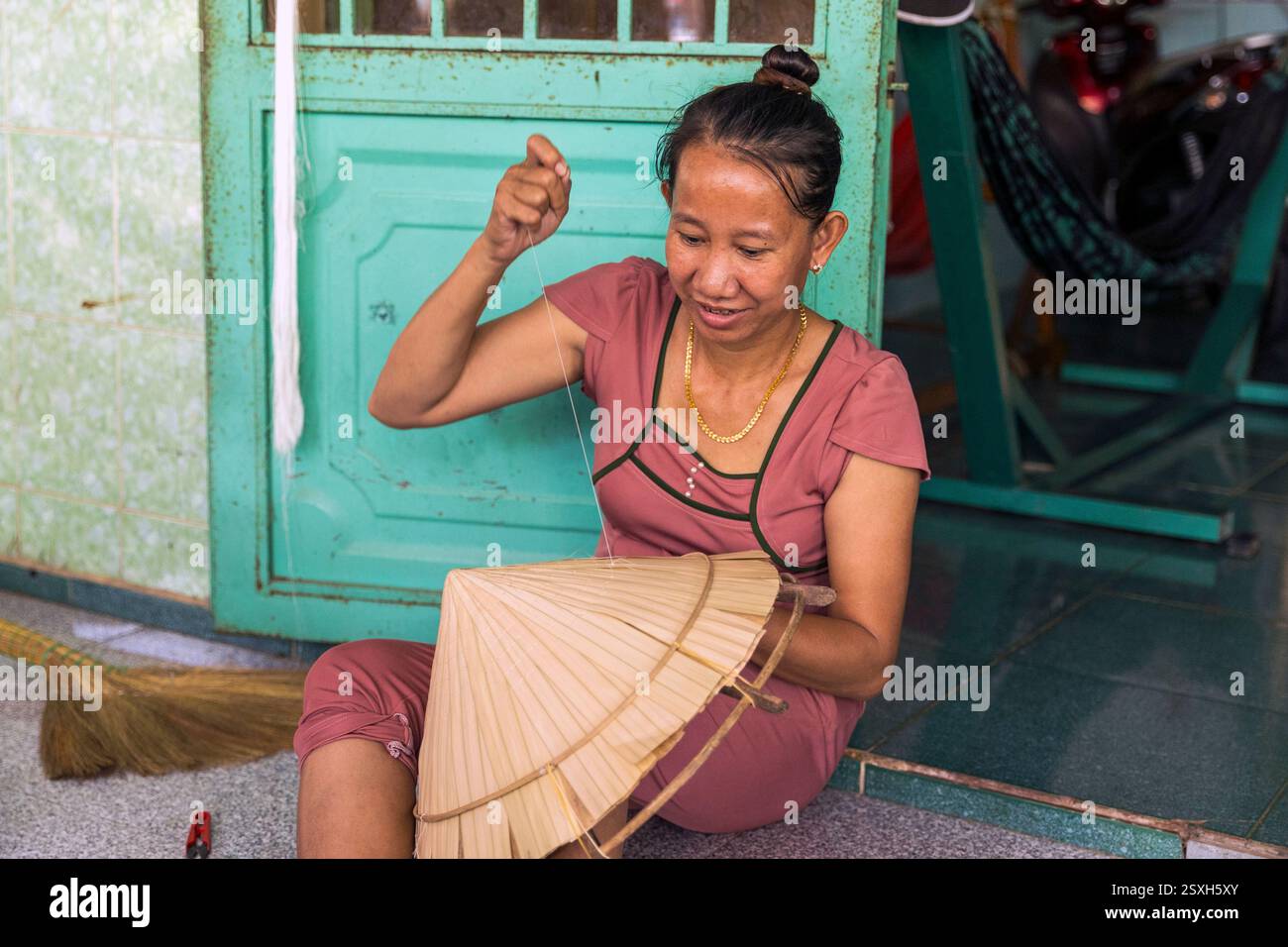 Une femme engagée dans le travail artisanal traditionnel faisant des chapeaux coniques en bambou à l'intérieur d'une maison sur Cu Lao Gieng ou Mango Island, Vietnam, Banque D'Images
