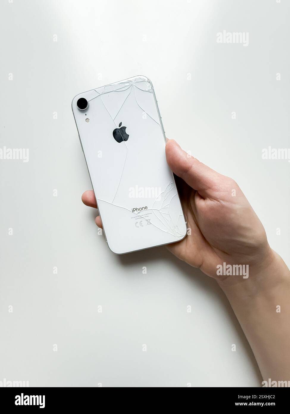 IPhone XR blanc écrasé dans la main Banque D'Images