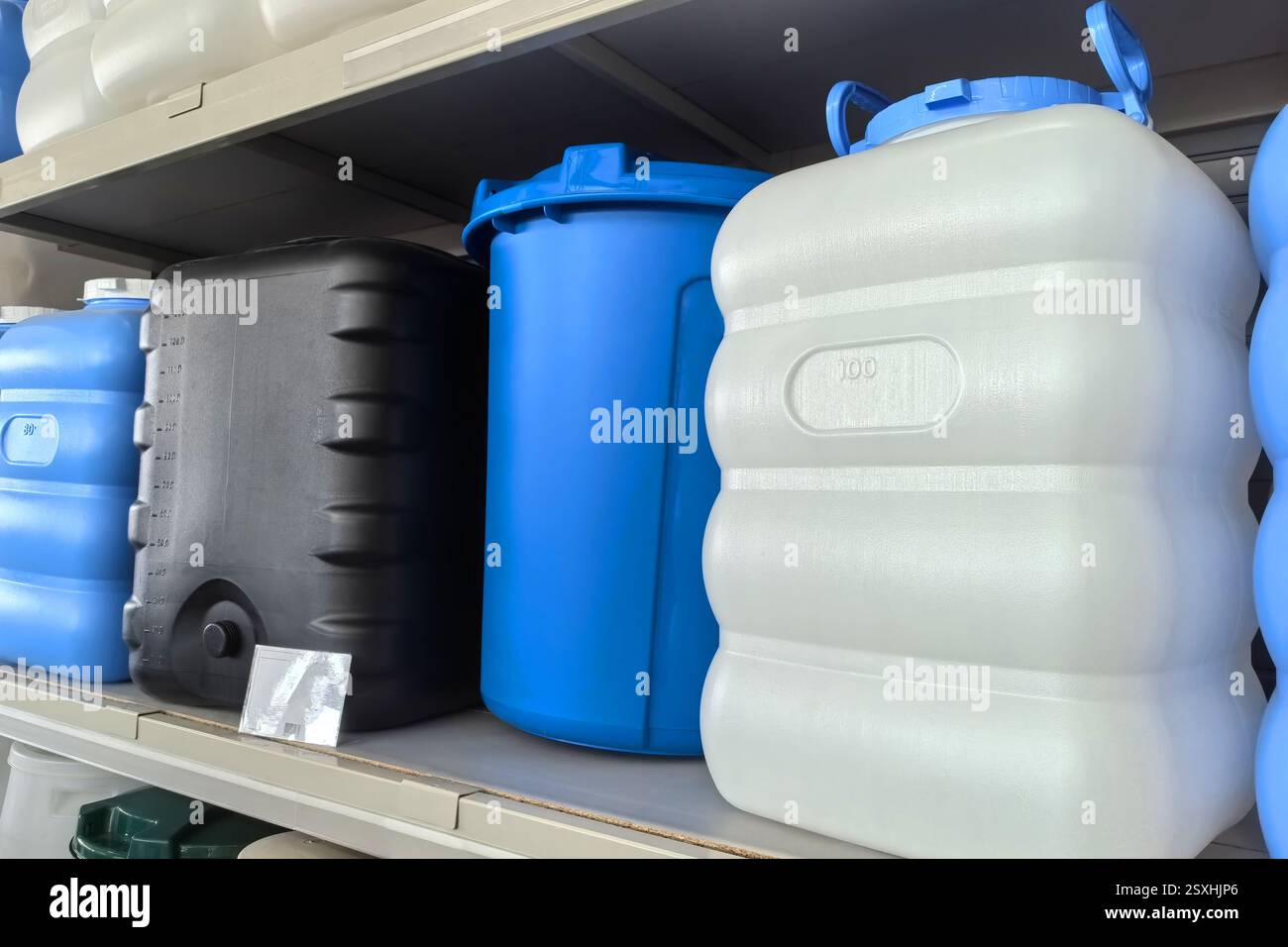 Divers conteneurs de stockage en plastique sont organisés soigneusement sur des étagères, mettant en valeur des couleurs vives. Le réglage semble être un espace utilitaire fonctionnel Banque D'Images