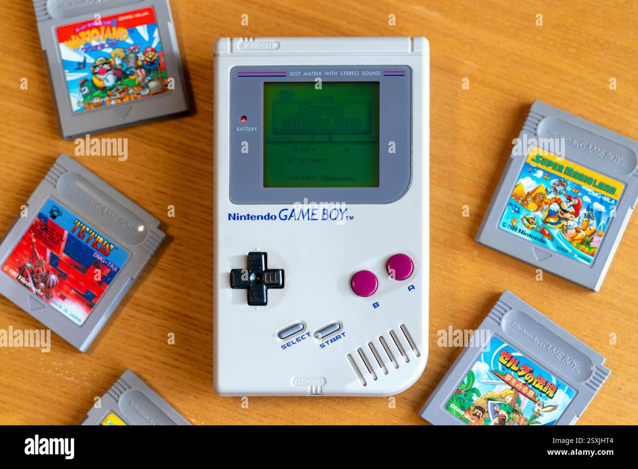 Fukuoka, Japon - 30 décembre 2024 : 1989 hit jeu super marioland fonctionnant sur nintendo Game Boy original sur une table en bois avec divers autres jeux à succès Banque D'Images Fukuoka, Japon - 30 décembre 2024 : 1989 hit jeu super marioland fonctionnant sur nintendo Game Boy original sur une table en bois avec divers autres jeux à succès Banque D'Images