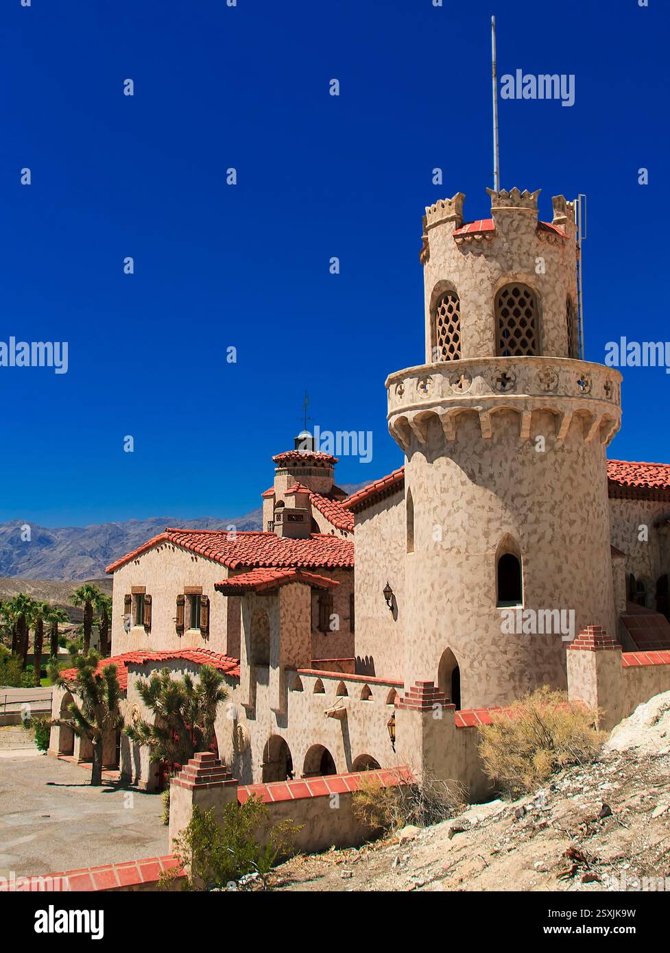 Grand bâtiment avec une tour sur le dessus. Le bâtiment est en pierre et a un toit rouge Banque D'Images