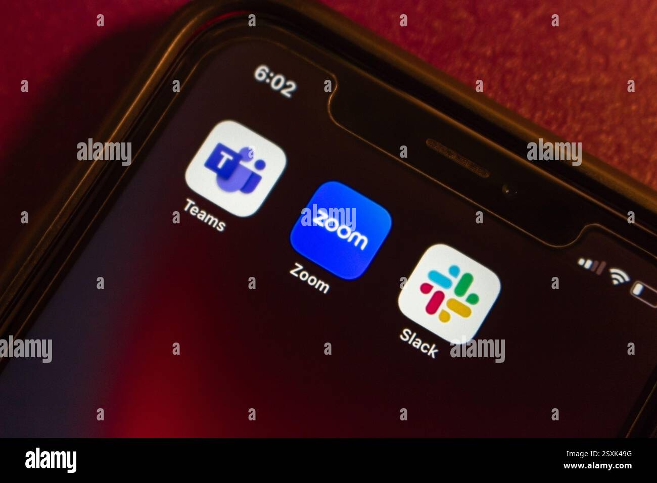 Les icônes Microsoft Teams, Zoom et Slack sont affichées sur un iPhone. Télétravail moderne, outils de communication et concept de travail collaboratif. Banque D'Images