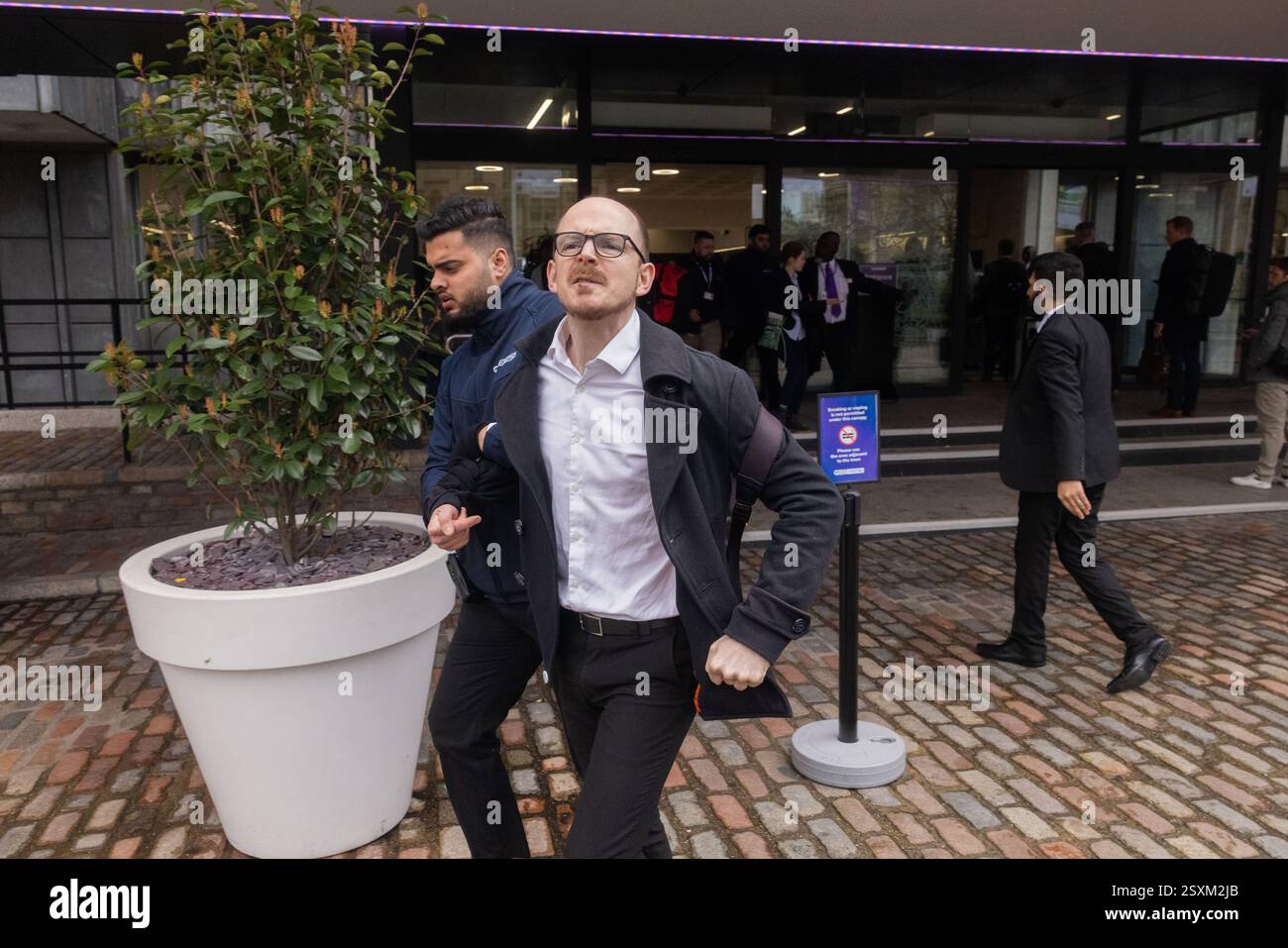 Londres, Royaume-Uni. 25 FÉVRIER 2025. Les manifestants crient à propos du champ pétrolier de Rosebank alors qu'ils sont retirés du centre de conférence QE 2 qui accueille actuellement la semaine internationale de l'énergie. Le groupe d'activistes Fossil Free London a confirmé qu'ils étaient responsables de l'action. Le centre, entouré par une forte sécurité, accueille également la conférence de la NFU. Crédit Milo Chandler/Alamy Live News Banque D'Images