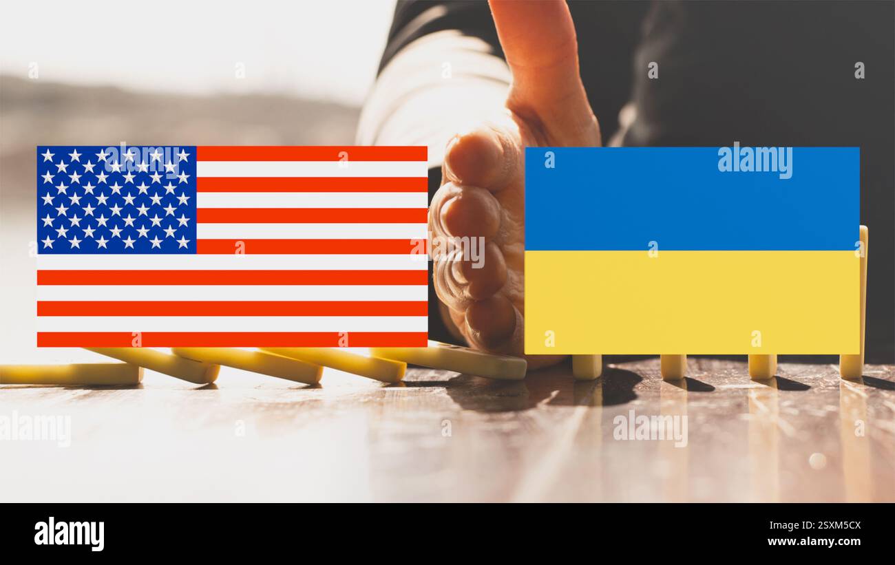 La jeune fille bloqua les dominos tombants sur la table avec sa main, et au premier plan se trouvaient les drapeaux de l'Ukraine et de l'Amérique, et entre eux un woma Banque D'Images