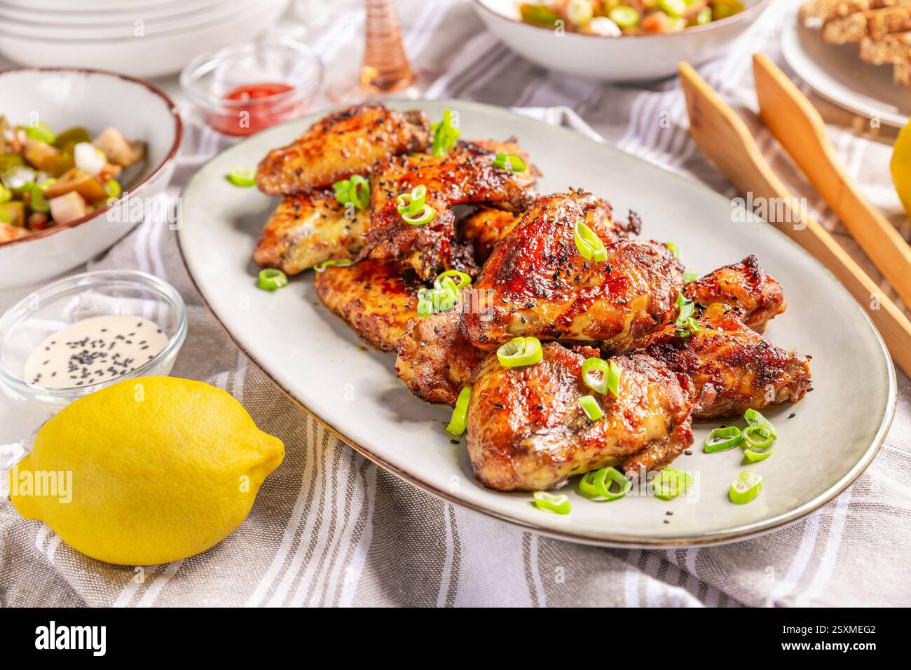 Table de pique-nique et repas en plein air, ailes de poulet avec salade mixte Banque D'Images