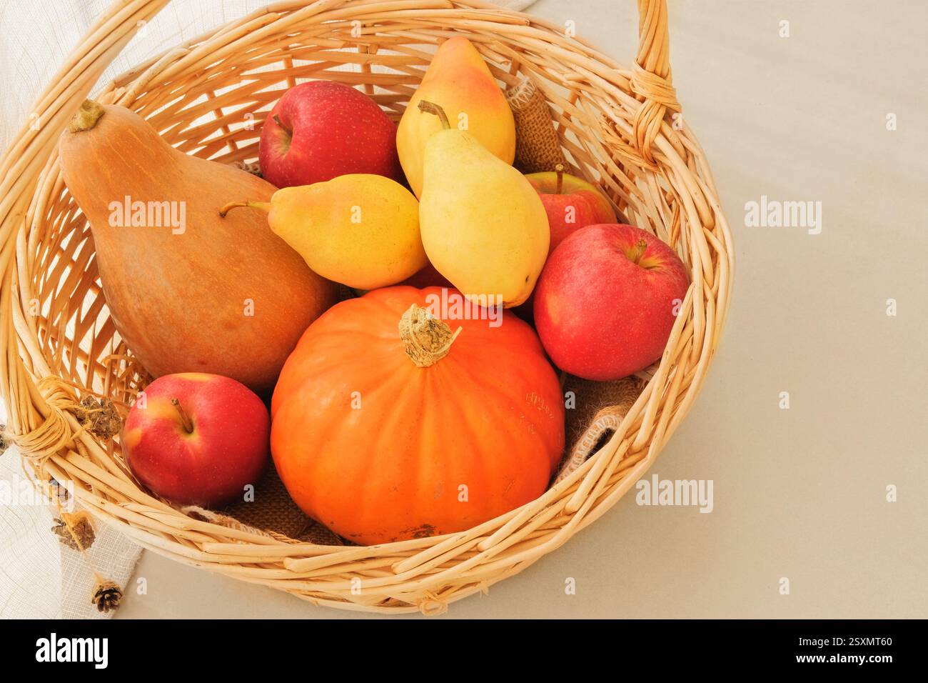 Pommes, poires et citrouilles dans un panier de paille. Fruits mûrs oranges. Les fruits sont un ingrédient populaire en cuisine. Vue de dessus. Placer pour le texte. Banque D'Images