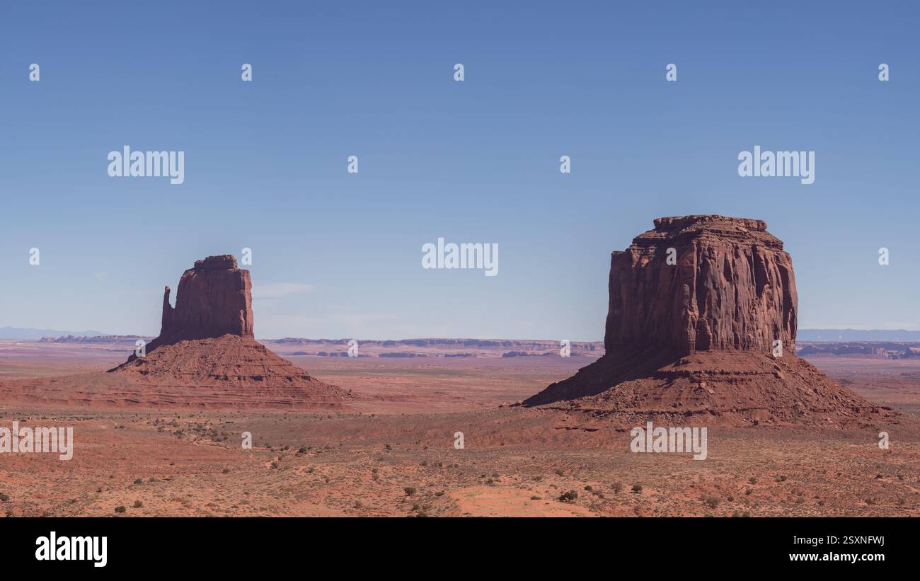 Les buttes emblématiques de Monument Valley s'élèvent au-dessus du désert aride sous un ciel bleu clair. Concept de nature, voyage, patrimoine amérindien, et Banque D'Images
