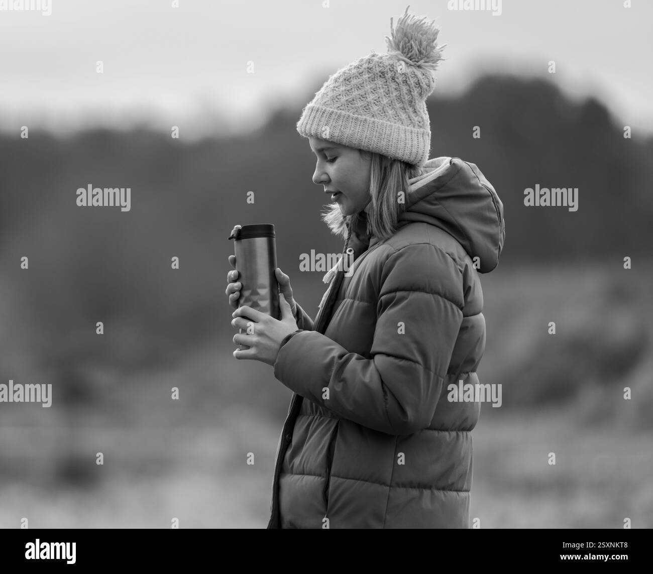 Dans photo noir et blanc, fille aime le thé chaud à l'extérieur en automne Banque D'Images