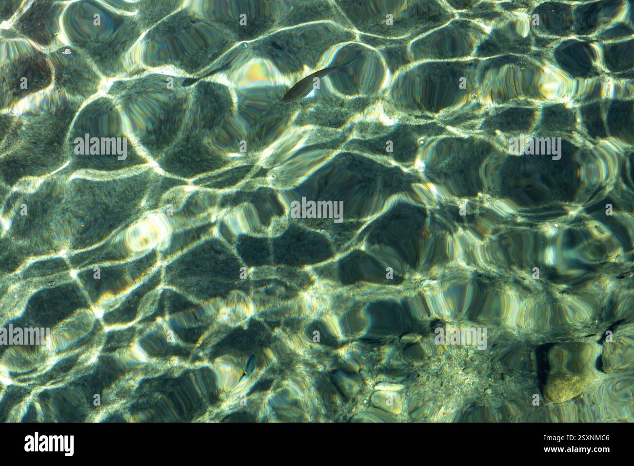 Soleil reflétant des motifs abstraits de lumière dans la mer. Banque D'Images