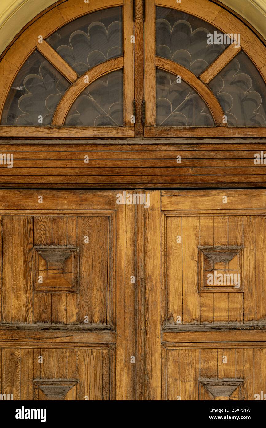 Porte en bois arquée avec panneaux de verre décoratifs et détails sculptés dans le style Vintage Banque D'Images