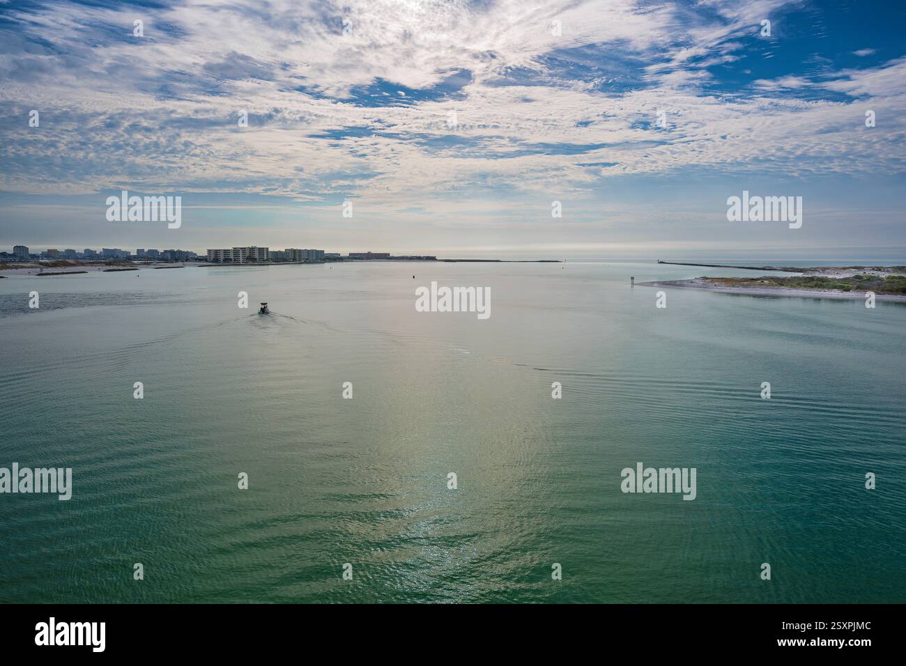 Bateau au départ de destin Harbor, naviguant dans les eaux émeraude sous un ciel bleu nuageux. Banque D'Images