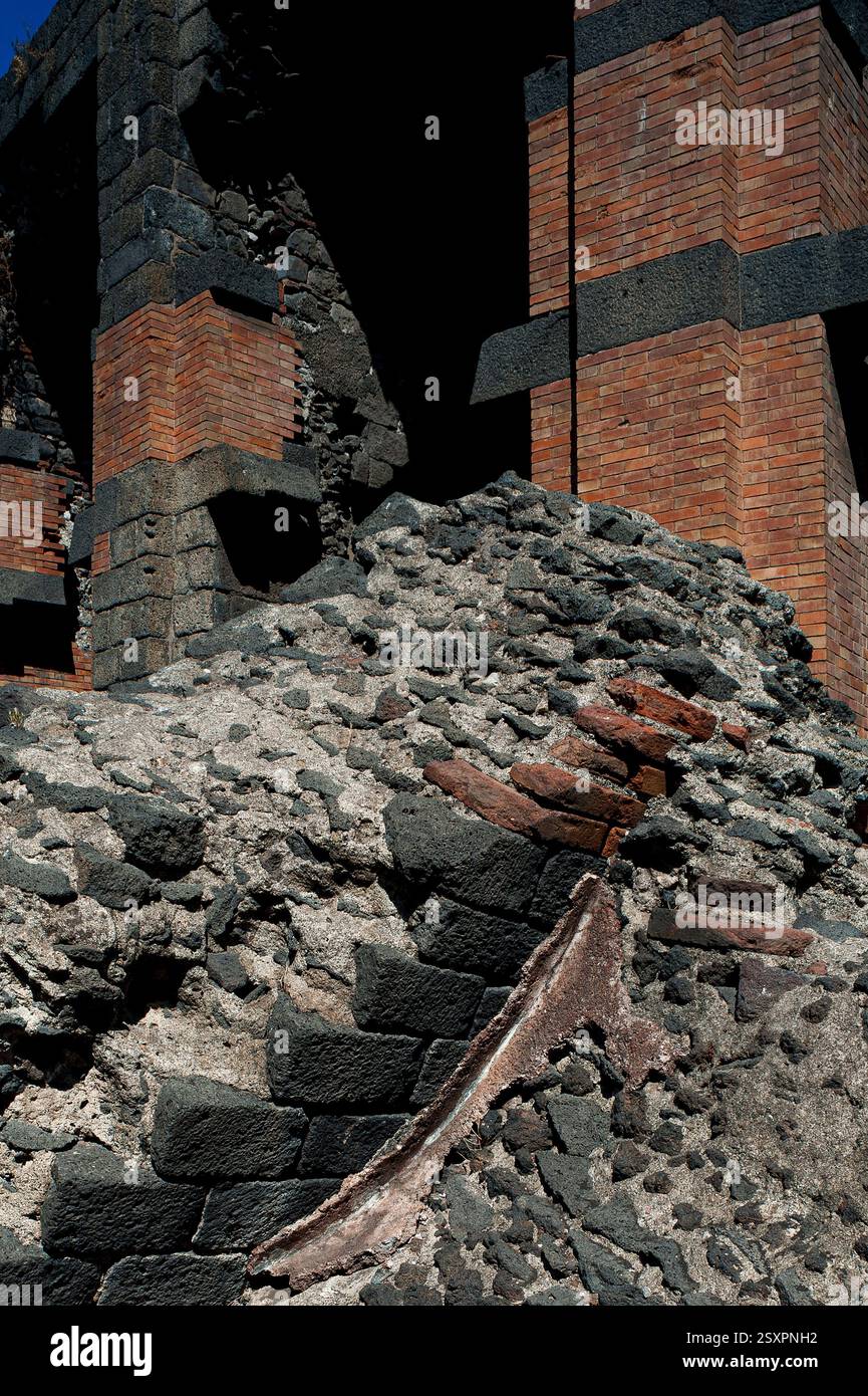 La maçonnerie romaine avec des gravats de mortier face à du basalte noir carré se trouve dans la passerelle à l'extérieur des arches soutenant les caveae ou sièges de l'Odéon de 1 500 capacité de l'ancienne Catane, aujourd'hui la ville de Catane, Sicile, Italie. L'Odéon du IIe siècle de notre ère jouxte le Théâtre romain de 7 000 places et a probablement été utilisé pour de petits événements et répétitions. Banque D'Images