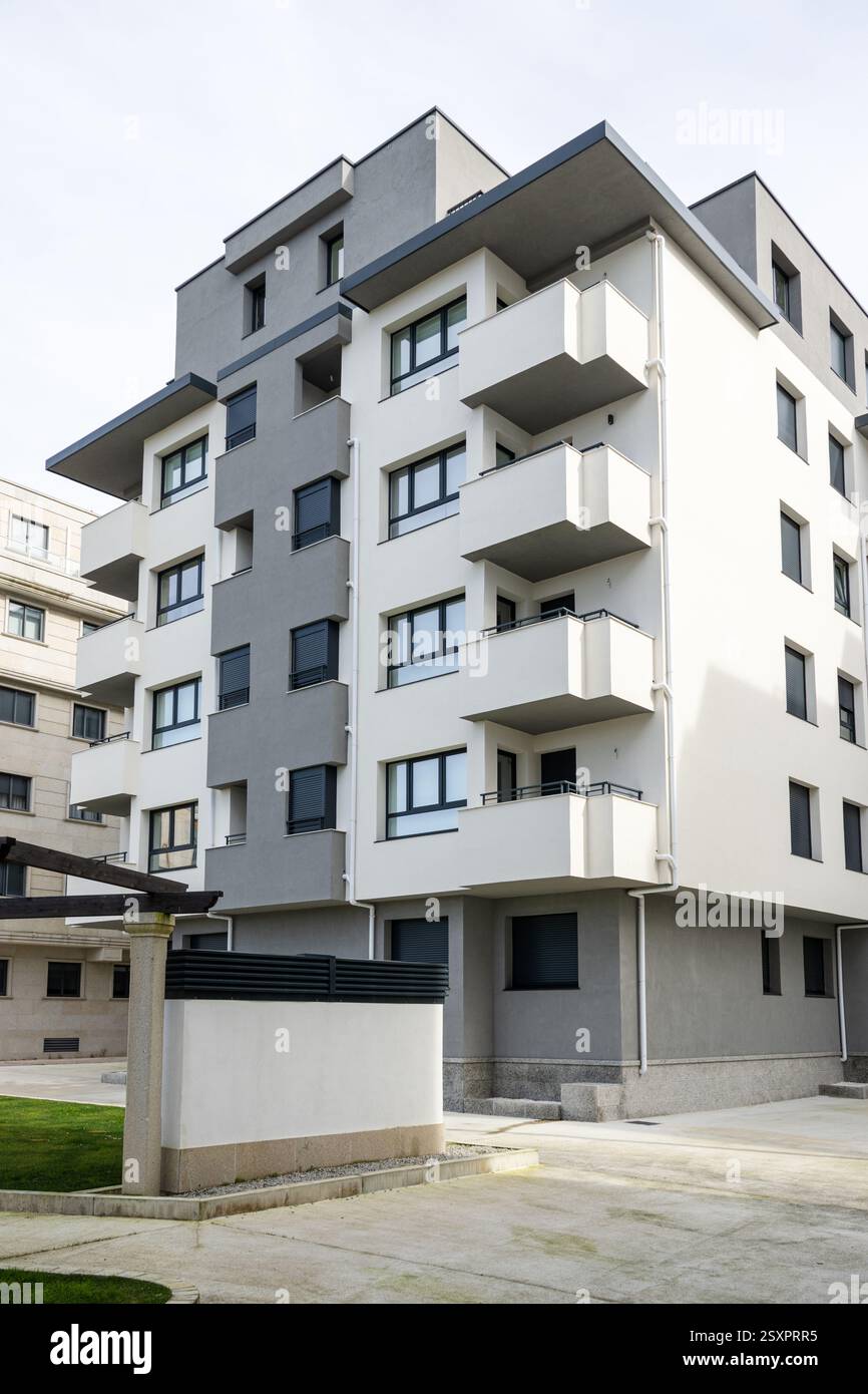 Bâtiment résidentiel moderne générique blanc et gris avec balcons et volets noirs Banque D'Images