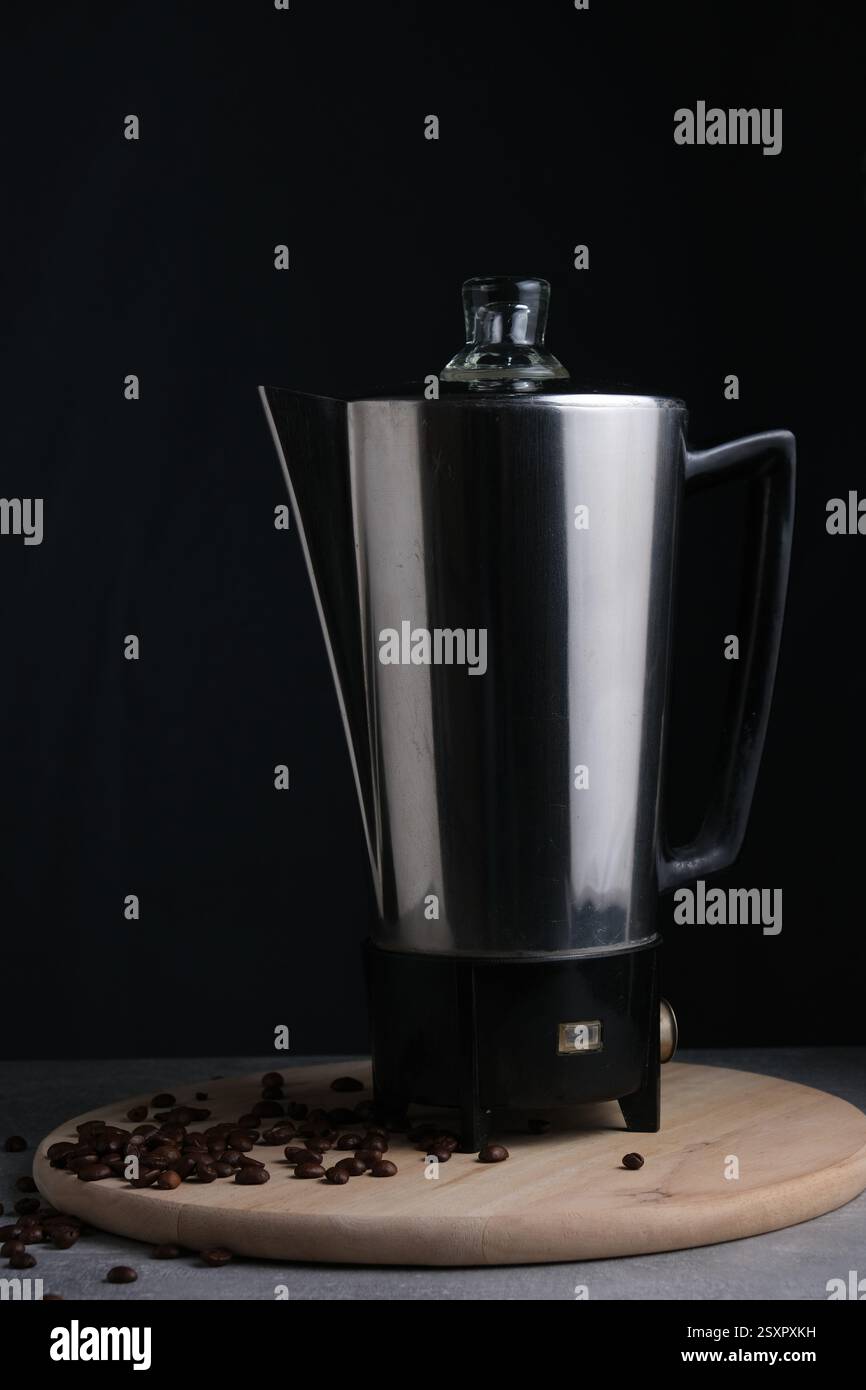 Cafetière et grains de café sur fond noir, prise de vue studio Banque D'Images