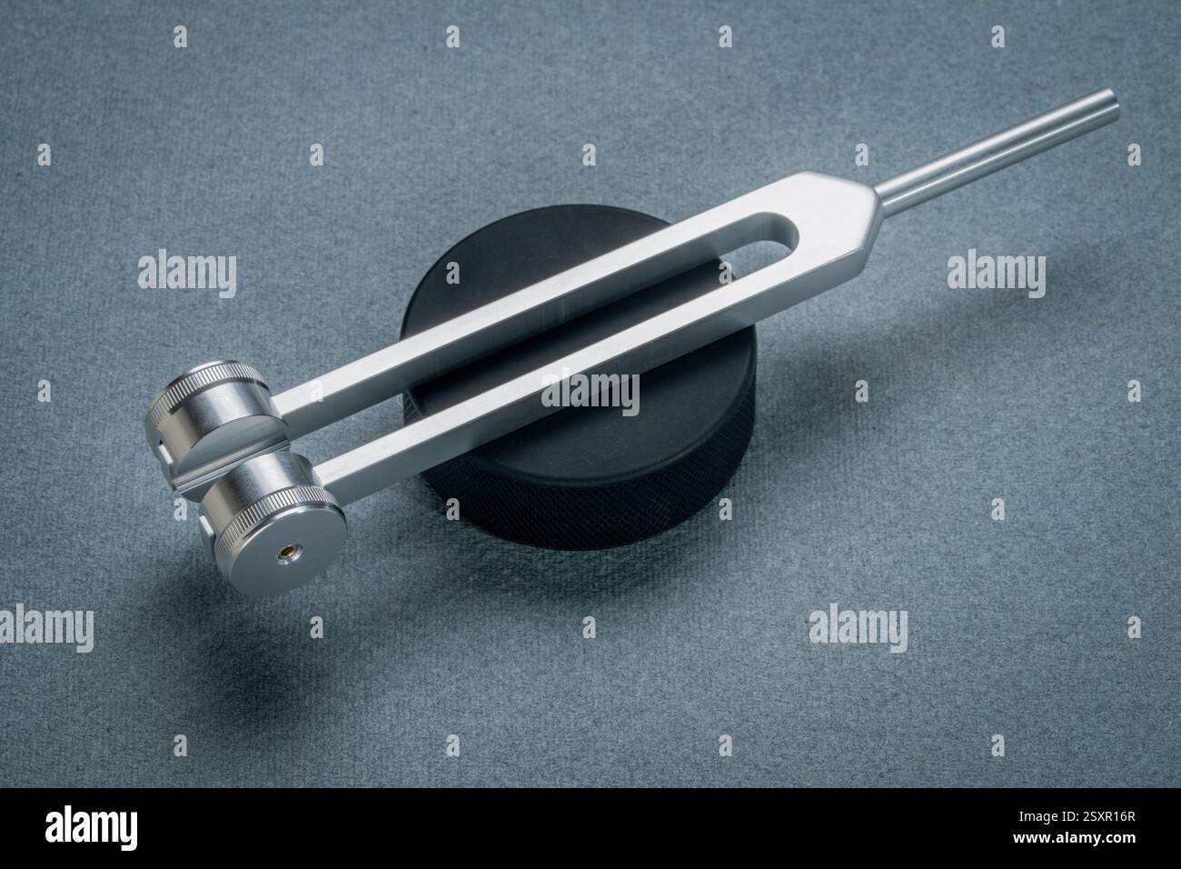 Diapason pondéré en métal utilisé pour accorder des instruments de musique, la thérapie sonore, la guérison ou la relaxation du chakra, l'actovator de palets de hockey. Banque D'Images