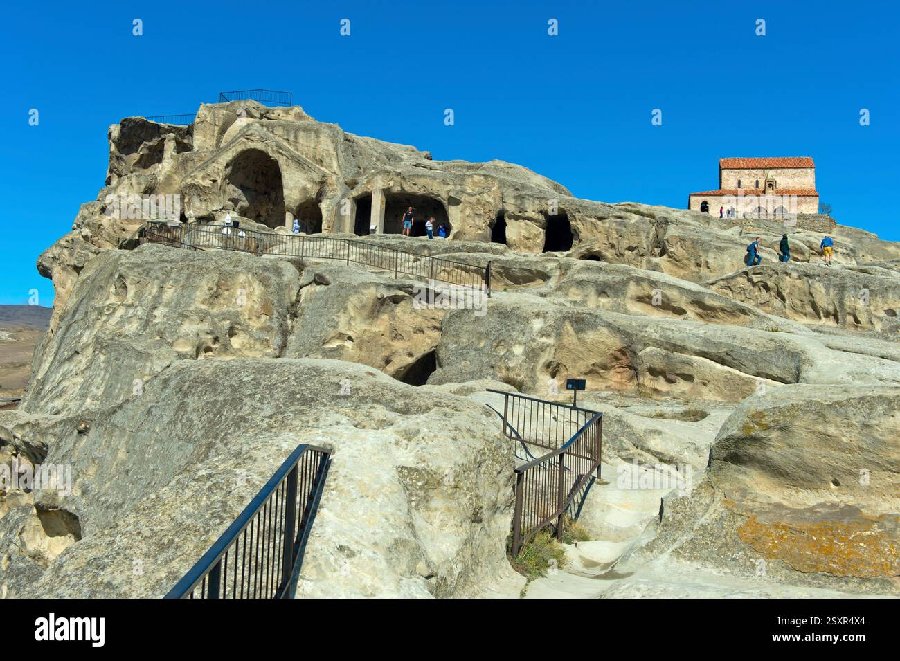 Bâtiments de grottes, basilique du Prince derrière, dans l'ancienne ville taillée dans la roche Uplistsikhe près de Gori, Géorgie Banque D'Images