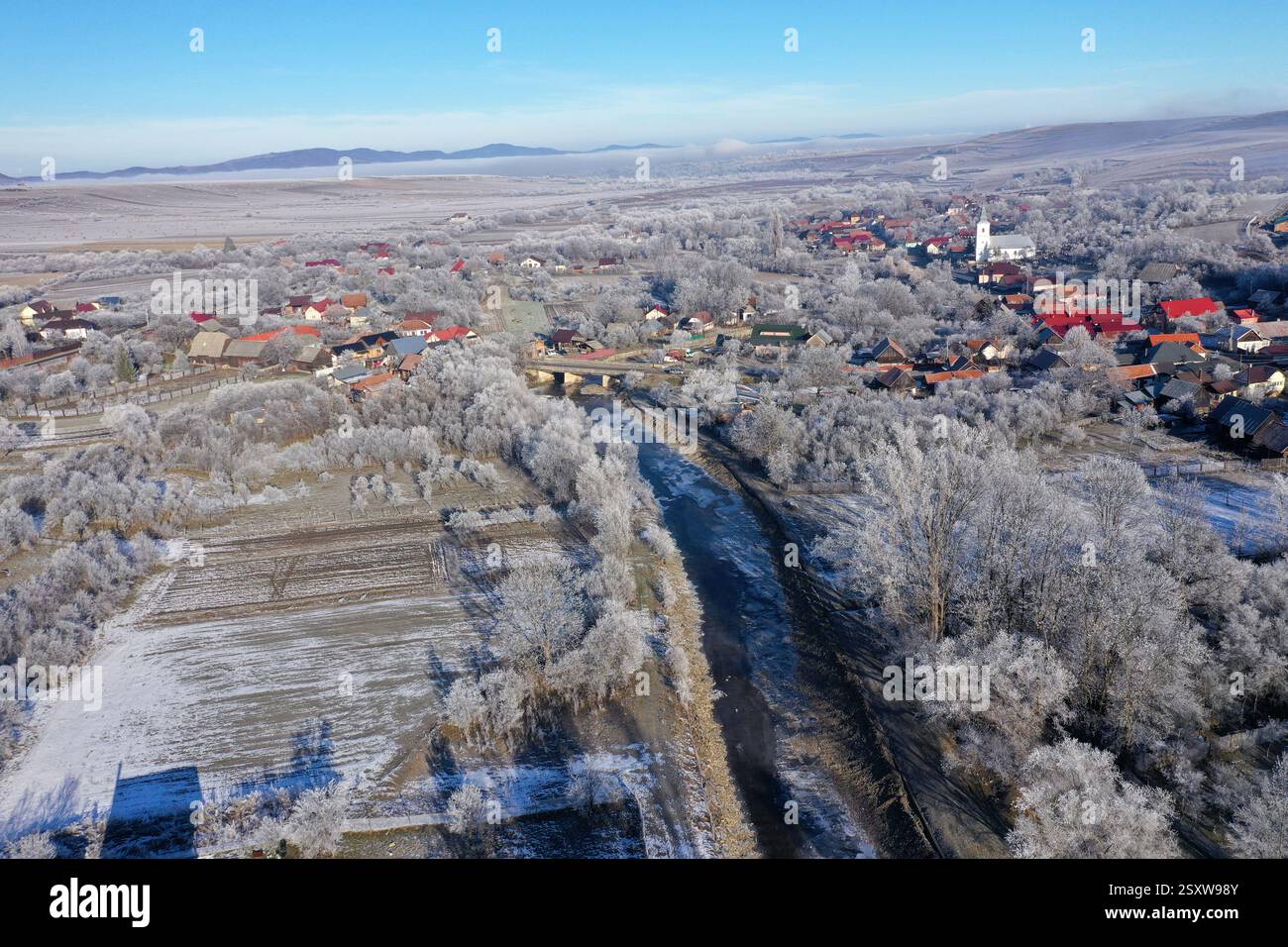 Vue aérienne d'un village de campagne brumeuse, dans les lumières tôt le matin par drone Banque D'Images