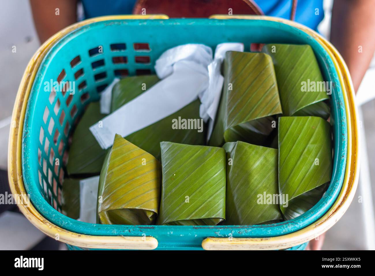 Dessert local traditionnel à base de millet, connu sous le nom de bingka dawa, un gâteau de riz enveloppé dans des feuilles de banane dans le panier d’un vendeur à Cebu, aux Philippines Banque D'Images