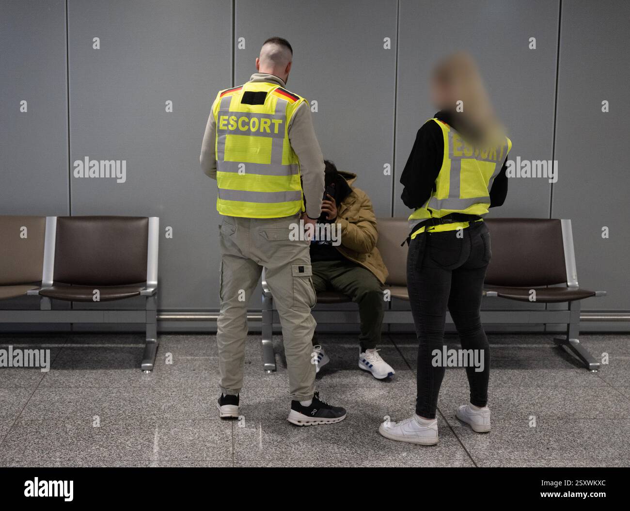 25 février 2025, Hesse, Francfort-sur-le-main : deux officiers de la police fédérale parlent à un homme avant qu'il ne soit emmené sur un vol d'expulsion vers le Pakistan. La police fédérale et le personnel de Frontex accompagnent le vol avec un déploiement massif de forces. Photo : Boris Roessler/dpa Banque D'Images