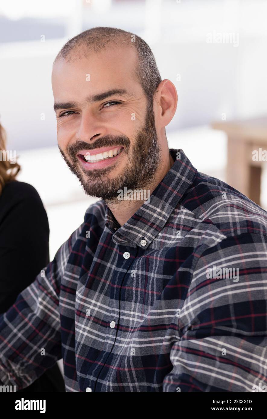 Homme souriant dans la chemise à carreaux appréciant la réunion d'affaires en plein air au food truck Banque D'Images