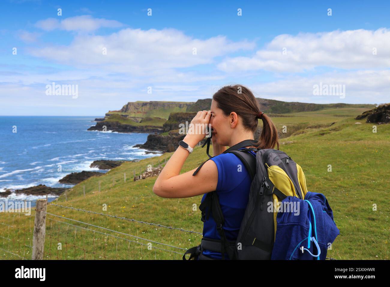 Causeway Coast Way sentier de randonnée menant à Giant's Causeway en Irlande du Nord. Nature du comté d'Antrim. Femme touriste prenant des photos en Irlande. Banque D'Images