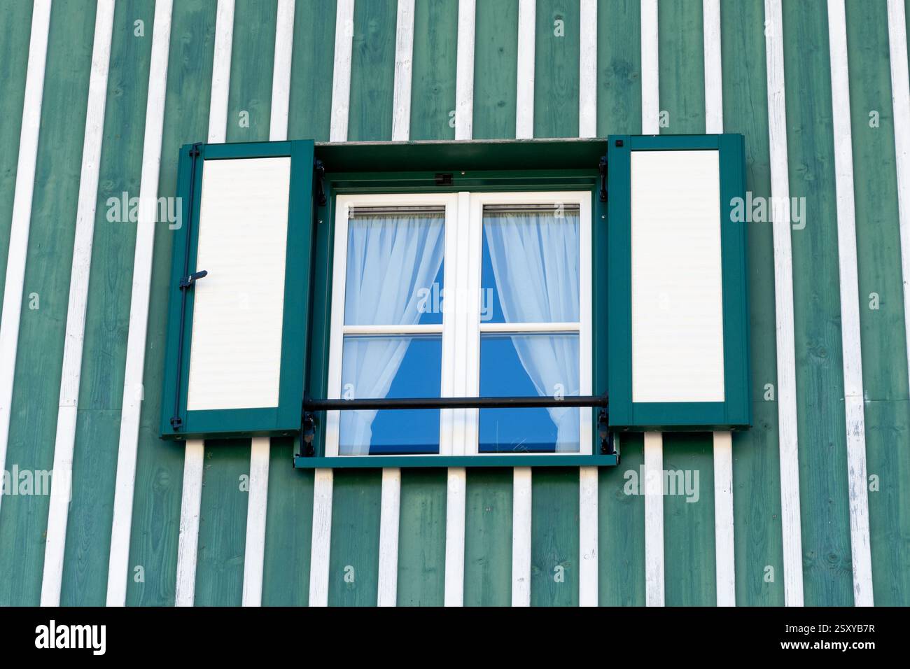 Style rustique : fenêtre dans une maison rustique - gros plan d'une fenêtre avec des rideaux contre des murs en bois dans un style traditionnel Banque D'Images