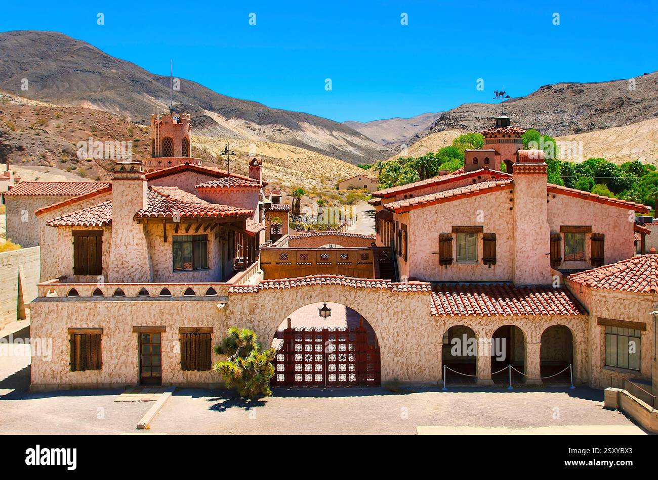 Grande maison avec un toit rouge et une garniture blanche. La maison est entourée d'une grande cour Banque D'Images