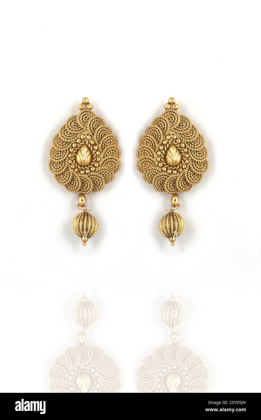 Belle paire d'or de boucles d'oreilles sur fond blanc. Bijoux féminins de luxe, bijoux traditionnels indiens, boucles d'oreilles kundan, boucles d'oreilles mariées en or Banque D'Images