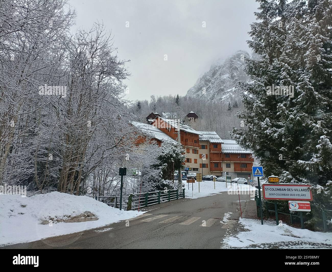 Panneau de Saint-Colomban-des-Villards et rue enneigée dans la vallée de la Maurienne, Savoie, Alpes françaises Banque D'Images